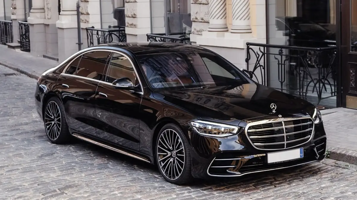 Black Mercedes S-Class executive chauffeur car parked outside an elegant building